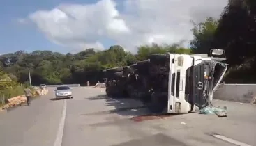 Caminhão tomba na BR-101 e parte da carga de pallet é levada por populares